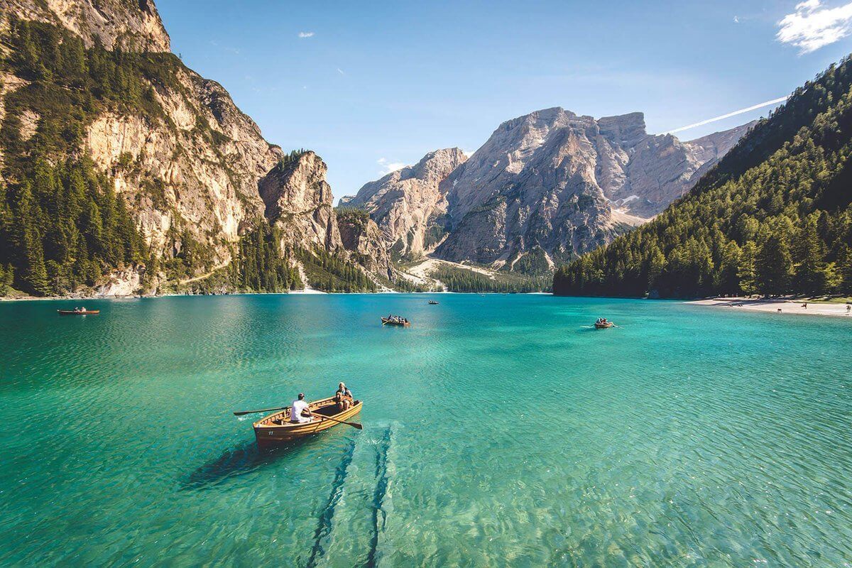 three brown wooden boat on blue lake