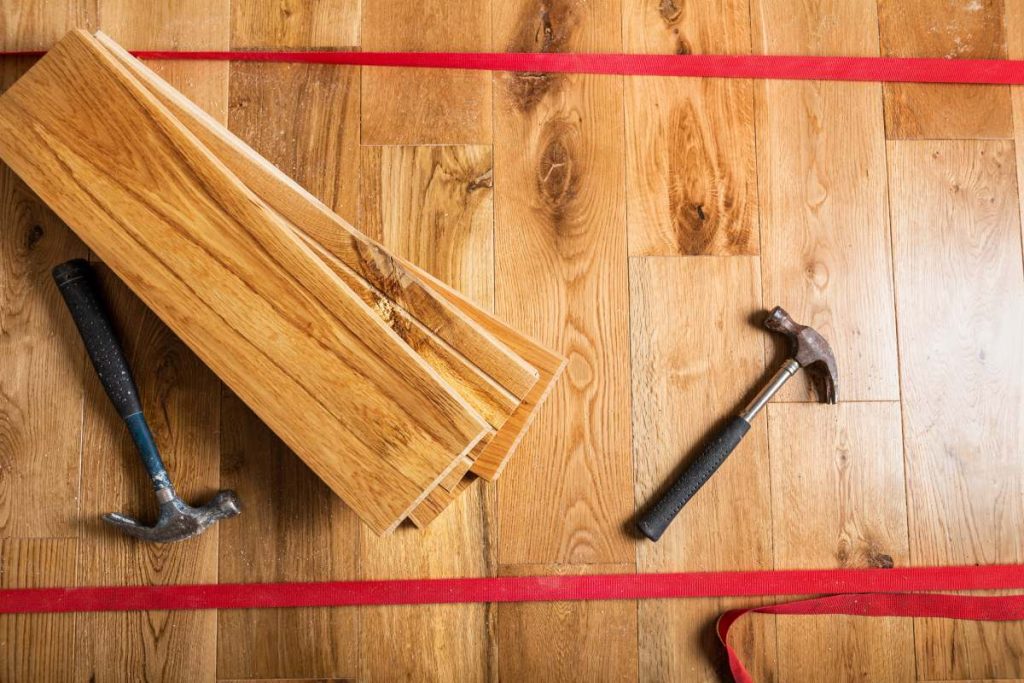 The process of house renovation with changing of the floor from carpets to solid oak wood. Different tools and materials on the new floor