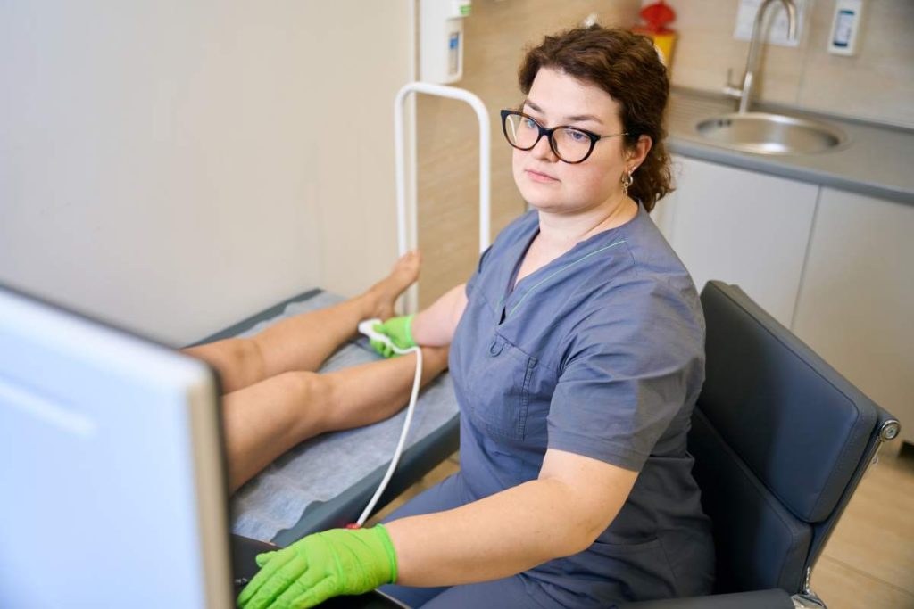 Medical worker at the workplace conducts an ultrasound diagnosis, the patient lies on a medical couch